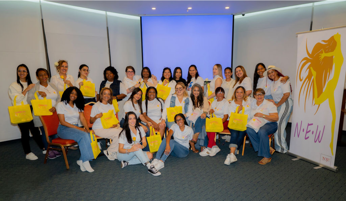 Grupo de mujeres en encuentro formativo con bolsas amarillas