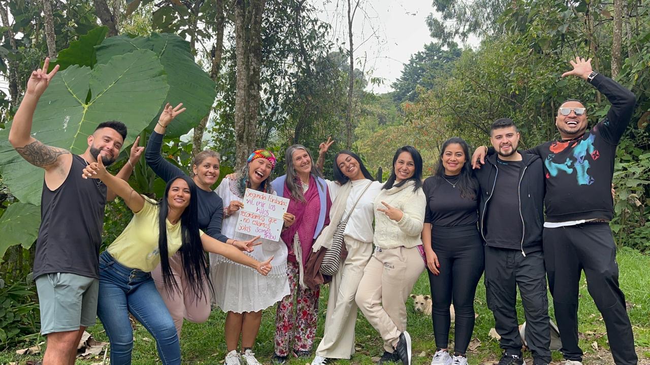 Comunidad reunida en el bosque sosteniendo un mensaje